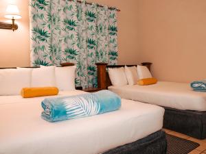 Habitación de hotel con 2 camas y toallas. en Kiskadee Korner Vacations, en Buccoo