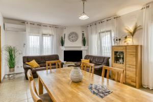 sala de estar con mesa de madera y sillas en Casa Elena en Sant Pere Pescador