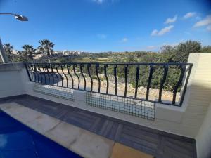 a balcony with a fence and a view of the beach at In-Nuffara Farmhouse, Nadur Gozo in Nadur