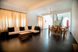 a living room with a couch and a table at Lankahuts Villa in Negombo