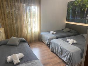 Habitación con 2 camas y toallas. en Hostal Restaurante Río Ubierna, en Quintanilla-Vivar