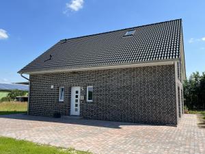 a large brick building with a white door at Ferienwohnungen EBBE und FLUT - Niedrigenergiehaus in Elpersbüttel