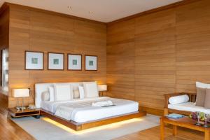 a bedroom with two beds and wooden walls at Adaaran Prestige Water Villas - with Dine around Premium All inclusive - 24 hours in Raa Atoll +37 photos