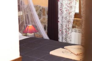 ガルガンティージャ・デル・ロソヤにあるPosada Rural SPA Granja LA TEJERA de Lozoyaのベッドルーム1室(窓際にランプ付きのベッド1台付)