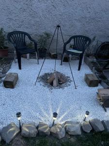 two chairs and a fire pit in a backyard at Keresztes Lak in Badacsonytördemic