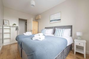 a bedroom with a large bed with towels on it at Harbour View Apartment at Royale Court Apartments Portrush in Portrush