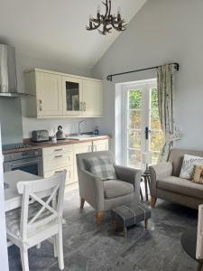 a kitchen with a couch and chairs and a table at Fern Cottage in Lynton
