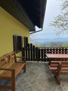 a patio with benches and a table and a fence at Boutique Tourist Farm Hrovat in Frankolovo