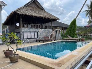 a swimming pool in front of a house at Ko Phangan Beach Cottages in Ban Tai