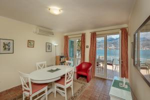uma sala de estar com uma mesa e cadeiras e uma varanda em Detached Villa with stunning views in Njivice, Montenegro em Njivice