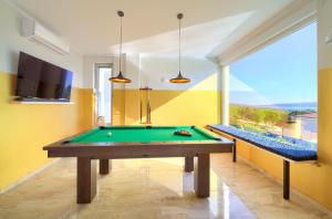 a room with a pool table and a tv at Villa PIANO in Pinezici