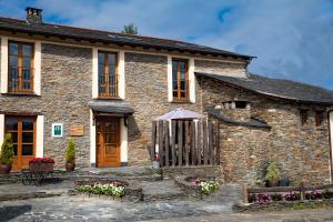 a stone house with an umbrella in front of it at Casa Ría de Navia in Navia