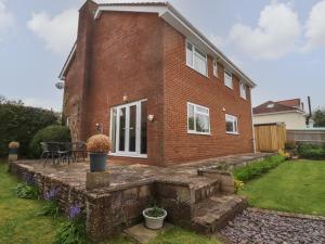 a brick house with a patio and a yard at Kingsford House in Ross on Wye