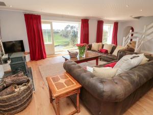 a living room with a leather couch and a table at Whiteadder Bank in Berwick-Upon-Tweed