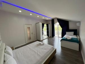a bedroom with two beds and a blue light at Qafqaz Paradise Villa in Gabala +22 photos