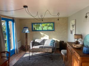 - un salon avec un canapé et une chaise dans l'établissement GITE "COTE JARDIN", à Vannecrocq