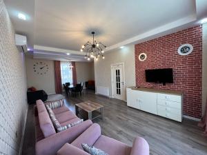 a living room with a couch and a brick wall at Qafqaz Paradise Villa in Gabala