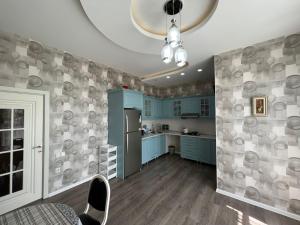 a kitchen with blue cabinets and a refrigerator at Qafqaz Paradise Villa in Gabala