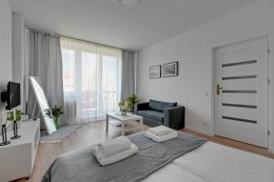 - un salon blanc avec un lit et un canapé dans l'établissement Downtown Apartments Old Town Stolarska, à Gdańsk