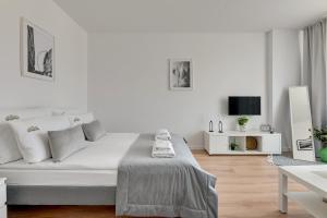 a white room with a bed and a tv at Downtown Apartments Old Town Stolarska in Gdańsk