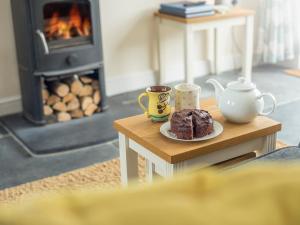 a table with a plate of cake and two cups of coffee at Golwg Y Cwm in West Cilrhedyn