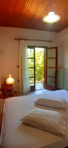 a bedroom with two beds and a large window at Golden Mountain in Anilio Pelion