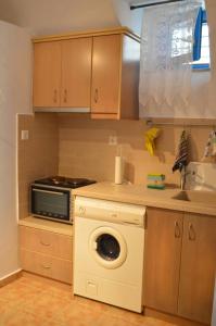 a kitchen with a washing machine and a microwave at Tholari project by S. in Astypalaia +24 photos