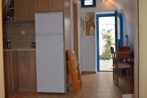 a white refrigerator in a kitchen with a table at Tholari project by S. in Astypalaia