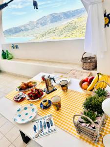 una mesa con comida en un mantel blanco y amarillo en Casa Molo 13 en Mattinata