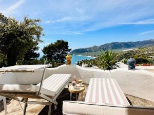 a patio with two chairs and a table and water at Casa Molo 13 in Mattinata