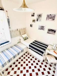 two beds in a room with a checkered floor at Casa Molo 13 in Mattinata