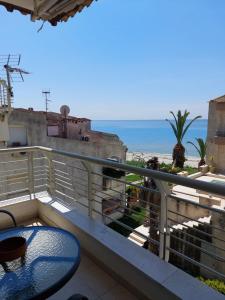 un balcone con tavolo e vista sull'oceano di Apartment in Siviri sea view a Siviri