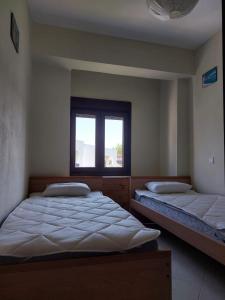 due letti in una stanza con finestra di Apartment in Siviri sea view a Siviri
