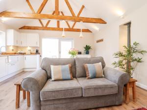 a living room with a couch and a kitchen at The Asparagus Shed in Sleaford