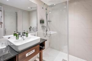 a bathroom with a sink and a shower at Melia Luxembourg in Luxembourg