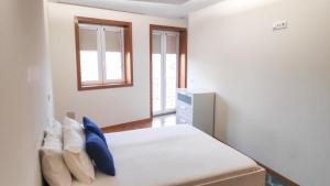 een slaapkamer met een bed met blauwe kussens bij Porta 116 - Free Private Parking in Vila Real