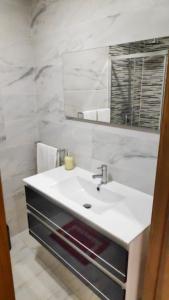 a bathroom with a white sink and a mirror at Porta 116 - Free Private Parking in Vila Real