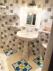 een badkamer met een wastafel, een spiegel en tegels bij Maison d'hôtes, superbe et spacieuse ,dans un cadre charmant calme et verdoyant in Pernes-les-Fontaines