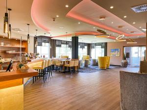a restaurant with a bar and tables and chairs at Morada Hotel Arendsee in Kühlungsborn