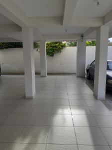 un estacionamiento con columnas blancas y un coche en Belo e Amplo Apartamento, Área Central da Praia dos Ingleses, en Florianópolis