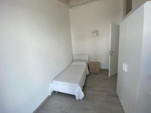 - une chambre blanche avec un lit dans l'établissement Villetta 6 La Caletta, à La Caletta