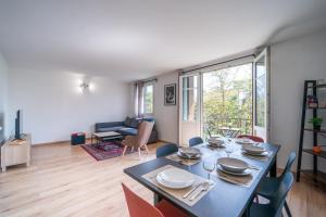 comedor con mesa y sillas en la sala de estar en Le Rosier - 20 min de Paris et d'Orly, en Vitry-sur-Seine