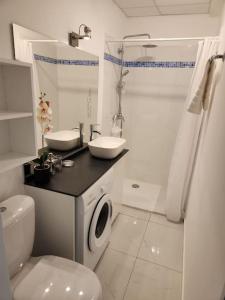 Baño blanco con aseo y lavamanos en Hello-Guyane, Marina 5, Studio Prestige 5 étoiles, en Saint-Laurent-du-Maroni