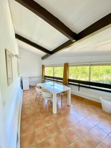 a dining room with a table and chairs and windows at Appartement spacieux 65M2, avec piscine et parking in Fréjus