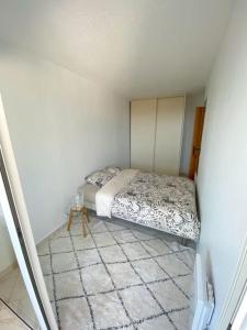 a small bedroom with a bed in the corner at Appartement spacieux 65M2, avec piscine et parking in Fréjus