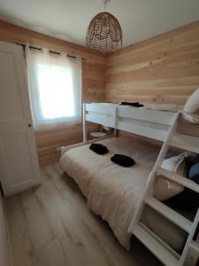 a bedroom with two bunk beds and a window at Chalet familial avec piscine chauffée, jeux et brasero- Morvan in Voudenay-lʼEglise +19 photos