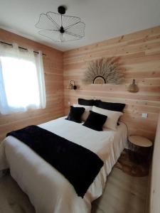 a bedroom with a large bed and a window at Chalet, aux portes du Morvan in Voudenay-lʼEglise
