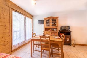 a dining room with a wooden table and chairs at La Ferme des Alpages - Proche pistes de ski in La Giettaz