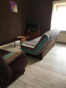 a living room with a bed and a table at Location Sylvie Herve Vosges in Saulxures-sur-Moselotte