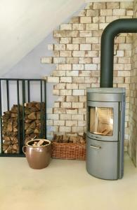 a wood fired oven in a room with a brick wall at Moorblick! Große Dachwohnung mit Kamin und Sauna in Leck